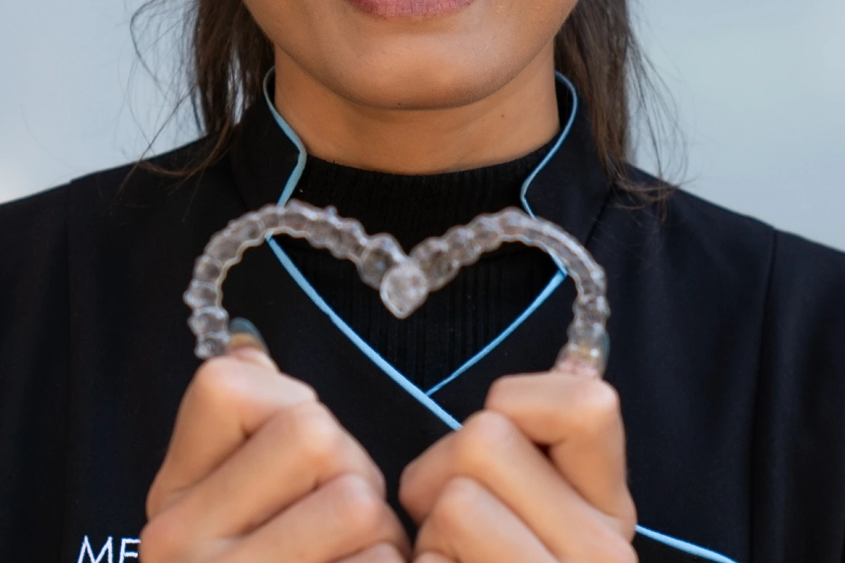An adult holding an Invisalign clear aligner An adult holding an Invisalign clear aligner